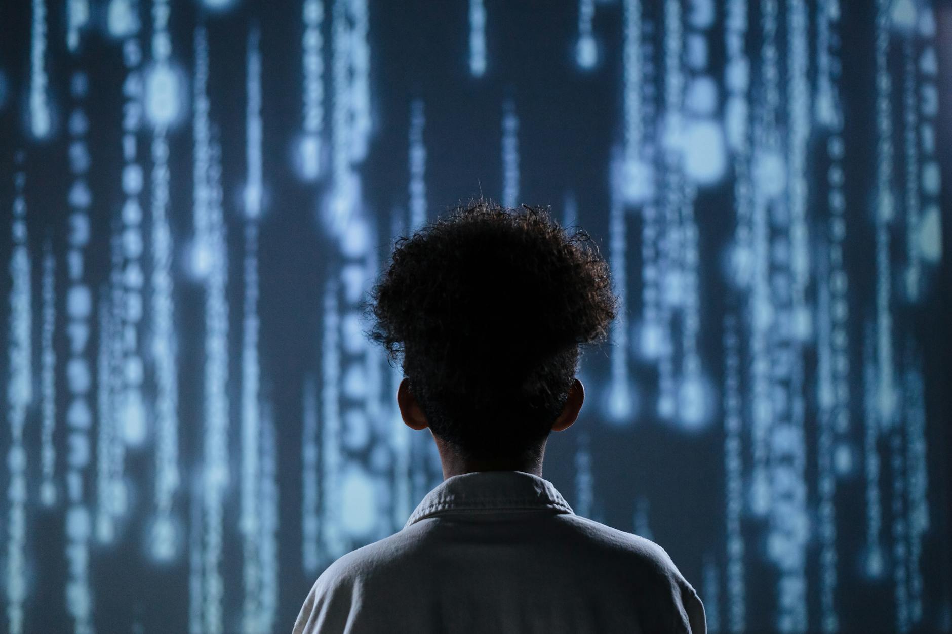 back view of a teen boy with a digital background